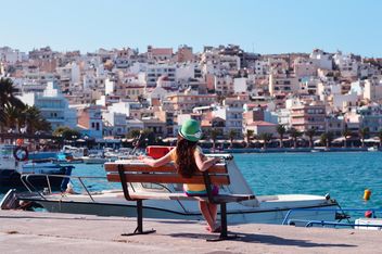 Girl sitting on sea embankment, Crete Island - бесплатный image #186711